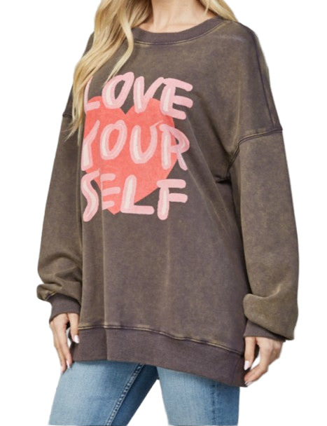 Woman wearing a brown sweatshirt with 'Love Your Self' text on a gray background