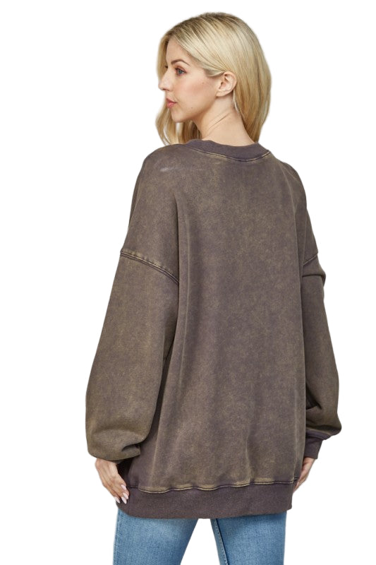 Woman wearing a brown oversized sweater against a white background