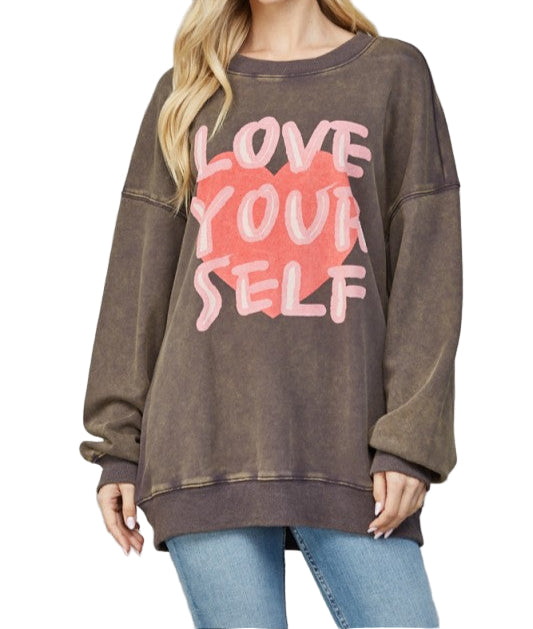 Woman wearing a brown sweatshirt with 'Love Your Self' text on a white background