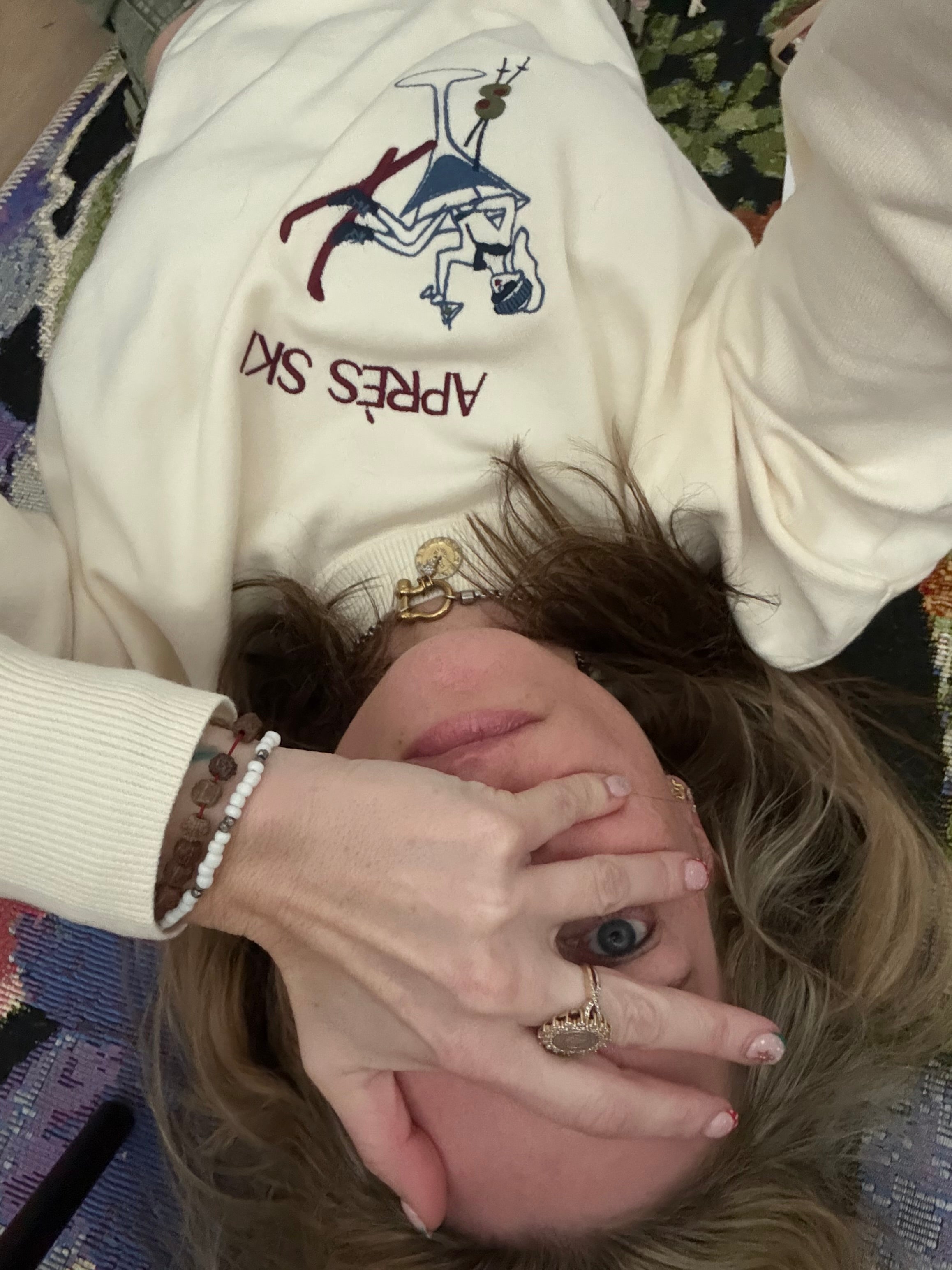 Lindsay wearing a pre-ski sweater while laying on floor