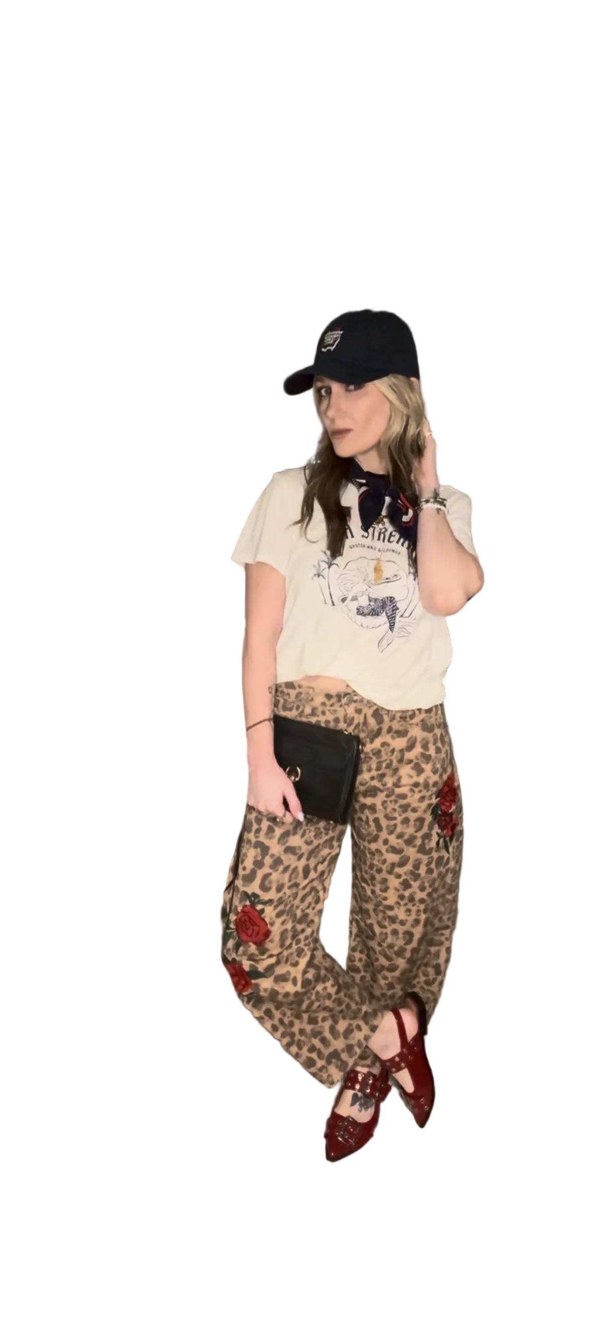 Lindsay, owner of kismet + sage wearing a leopard print Jean with roses embroidered on them with  graphic t-shirt, and navy cap.