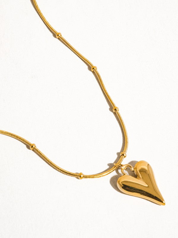 Gold heart-shaped pendant necklace on a white background