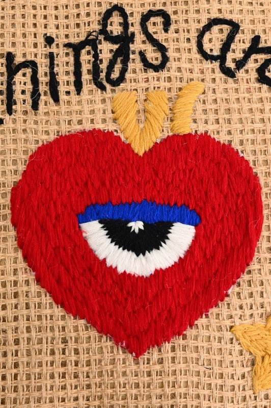 Heart-shaped patch with an eye design on a textured background