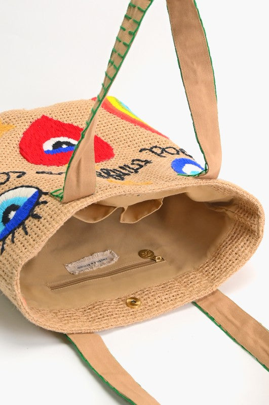 Woven handbag with colorful face designs and visible brand name on a white background