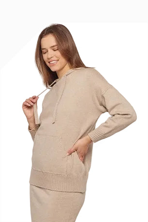 Woman wearing a beige sweater and skirt set on a white background