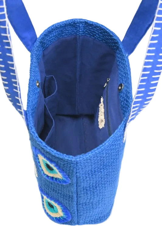 Blue woven no bad vibes bag with embroidered details on a white background