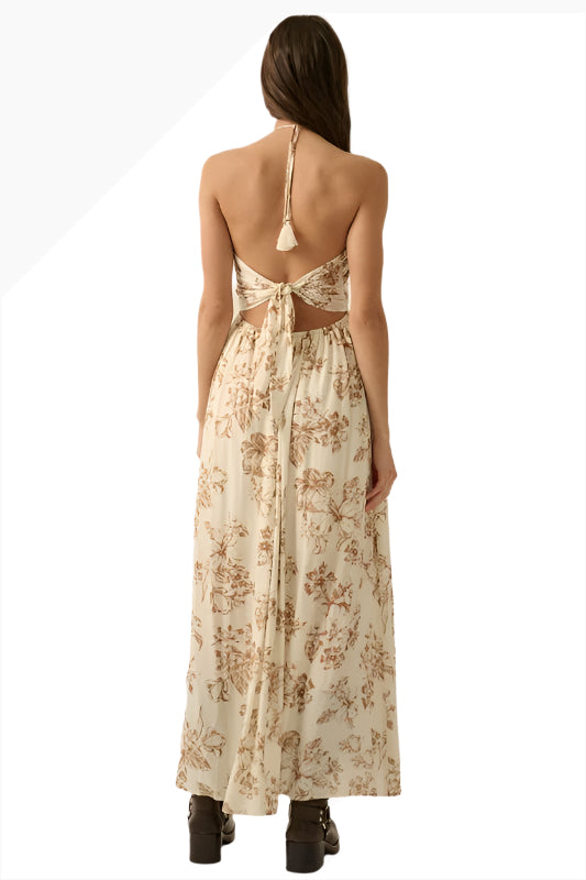 Woman wearing open-back halter maxi dress with tassel tie detail